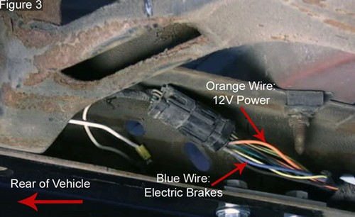 Closeup of trailer wiring harness on driver's side rear frame of full-size Ford