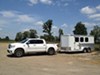 horse trailer being pulled by white truck. 