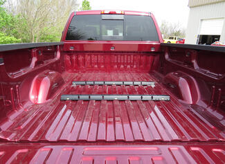 Aftermarket 5th-wheel rails in red pickup truck bed