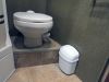 Camco wall mount trash can sitting in an RV bathroom.