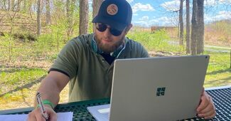 Remote worker outside writing 