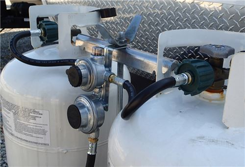 Two propane tanks connected with regulators.