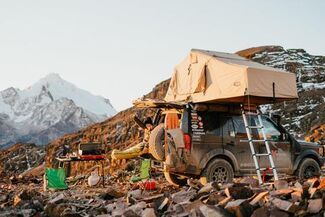 Overlanding in the mountains with vehicle and tent.