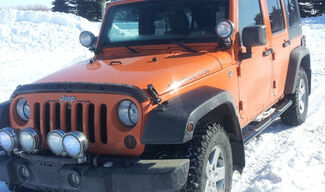 Orange Jeep Wrangler Rubicon in snow