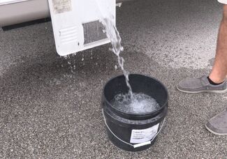RV water heater draining into a bucket