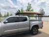 Paddle board mounting in the truck bed of a silver truck.