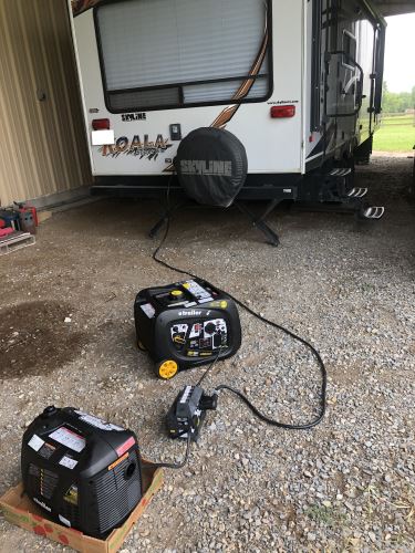 Image of two inverter generators with a parallel kit connected to a camper