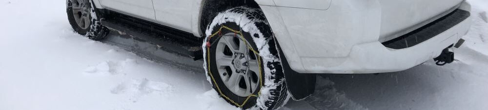 Tire chains on tire in snow.