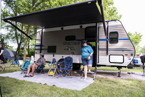 People camping in travel trailer at campground.